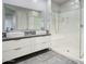 Modern bathroom featuring a double vanity, a large mirror, and a walk-in shower at 9543 W Donald Dr, Peoria, AZ 85383