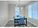 A simple dining room featuring minimalist modern lighting, light blue chairs, and a glass table at 9543 W Donald Dr, Peoria, AZ 85383