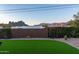 Backyard with green artificial turf, gravel landscaping, and views of the surrounding mountains, ideal for relaxation and play at 10142 E La Palma Ave, Gold Canyon, AZ 85118