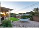 Serene backyard featuring a relaxing hammock, artificial turf, decorative rock, and lush greenery against a mountain backdrop at 10142 E La Palma Ave, Gold Canyon, AZ 85118