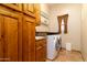 Well-equipped laundry room features modern washer and dryer with tile flooring and convenient cabinet storage at 10142 E La Palma Ave, Gold Canyon, AZ 85118