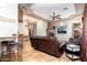Open living room with a stone fireplace, leather couches, tile floors, and decorative ceilings at 10142 E La Palma Ave, Gold Canyon, AZ 85118