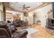 Spacious living room featuring tile floors, leather furniture, decorative ceilings, and a stone fireplace at 10142 E La Palma Ave, Gold Canyon, AZ 85118