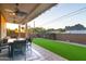 Covered patio with ceiling fans, dining set, and artificial turf, ideal for outdoor dining and enjoying the landscaped yard at 10142 E La Palma Ave, Gold Canyon, AZ 85118