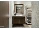Stylish powder room featuring a modern vanity, decorative wallpaper, and shelving at 10238 E Rising Sun Dr, Scottsdale, AZ 85262