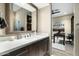 Stylish bathroom with a large mirror, modern sink, and a view into an office space at 10238 E Rising Sun Dr, Scottsdale, AZ 85262