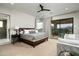 Large bedroom with ceiling fan, sitting area, and doors to the outdoor balcony at 10238 E Rising Sun Dr, Scottsdale, AZ 85262