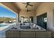 Spacious covered patio with comfortable seating, ceiling fans, and desert views, perfect for outdoor living at 10238 E Rising Sun Dr, Scottsdale, AZ 85262