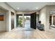 Modern entryway with wood floors, rug, and open door to desert landscape at 10238 E Rising Sun Dr, Scottsdale, AZ 85262