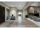 Long hallway with natural light, decorative rug, and a glimpse of the living room with a stone fireplace at 10238 E Rising Sun Dr, Scottsdale, AZ 85262