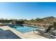 Serene backyard pool with lounge chairs, desert landscaping, and panoramic mountain views at 10238 E Rising Sun Dr, Scottsdale, AZ 85262