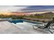 A pristine swimming pool at dusk with beautiful views of the natural landscape at 10238 E Rising Sun Dr, Scottsdale, AZ 85262