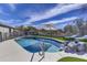 Backyard swimming pool with a rock feature, surrounded by a concrete deck and artificial grass at 10262 E Jasmine Dr, Scottsdale, AZ 85255