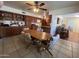 Cozy dining area with a ceiling fan, wood table, and views into the kitchen and living area at 10402 N Balboa Dr, Sun City, AZ 85351