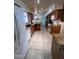 Long kitchen featuring wooden cabinetry, tiled floor, granite countertops and white appliances at 10402 N Balboa Dr, Sun City, AZ 85351