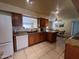 Charming kitchen with wood cabinets, tile floors, white appliances, and granite countertops at 10402 N Balboa Dr, Sun City, AZ 85351