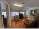 Bright living room featuring wood flooring, a comfortable chair, and natural light from windows at 10402 N Balboa Dr, Sun City, AZ 85351