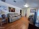 Comfortable living room with a plush sofa, wood flooring, and access to other rooms at 10402 N Balboa Dr, Sun City, AZ 85351