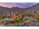 Aerial view showing the pool, outdoor kitchen, and patio of this desert home and its mountain views at 10935 E Grandview Way, Scottsdale, AZ 85255