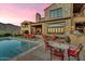 Stunning backyard with stone house, pool, lounge chairs, dining table, mountain views, and outdoor grill at 10935 E Grandview Way, Scottsdale, AZ 85255