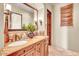 Well-lit bathroom with dual sinks, granite counters, and a decorative mirror at 10935 E Grandview Way, Scottsdale, AZ 85255