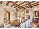 Elegant dining room features a decorative chandelier, wood beams, fireplace and dining table at 10935 E Grandview Way, Scottsdale, AZ 85255