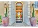 Elegant home entrance featuring stone archway, large planters, and glass front door at 10935 E Grandview Way, Scottsdale, AZ 85255