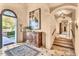 Elegant foyer with wooden cabinet, tiled floors, and staircase leading up to next level at 10935 E Grandview Way, Scottsdale, AZ 85255