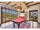 Bright game room with exposed beams, pool table, and glass doors to the outside at 10935 E Grandview Way, Scottsdale, AZ 85255
