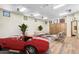 Living room with a red car, seating area, and wood paneled walls with athletic themed pictures at 10935 E Grandview Way, Scottsdale, AZ 85255