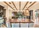 Open kitchen and dining area features wood beams and a large dining table at 10935 E Grandview Way, Scottsdale, AZ 85255