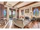 Comfortable living room with fireplace, wood floors, and view of backyard through glass doors at 10935 E Grandview Way, Scottsdale, AZ 85255