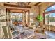 Inviting living room featuring stone walls, views, and comfortable seating at 10935 E Grandview Way, Scottsdale, AZ 85255
