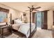 Comfortable bedroom with four-poster bed, ceiling fan, and private balcony access at 10935 E Grandview Way, Scottsdale, AZ 85255