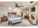 Serene main bedroom with a stone fireplace, carpeted floor, and ceiling fan at 10935 E Grandview Way, Scottsdale, AZ 85255