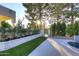 Beautifully landscaped backyard with lush greenery, red flowers, and a gated entrance to a refreshing pool at 11578 N 80Th Pl, Scottsdale, AZ 85260