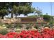 Stone sign for Scottsdale Country Club with colorful flowers, cacti, and lush green foliage at 11578 N 80Th Pl, Scottsdale, AZ 85260