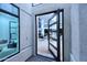 Modern home entryway showcasing a pivoting glass door and bright, open space with a glimpse of the living area at 11578 N 80Th Pl, Scottsdale, AZ 85260