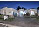 A modern-designed home at night with a circular driveway, a black garage door, and stylish landscaping at 11578 N 80Th Pl, Scottsdale, AZ 85260