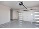 Spacious garage featuring epoxy flooring, access door, and insulated garage door with horizontal windows at 11578 N 80Th Pl, Scottsdale, AZ 85260