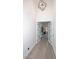 Hallway with light wood floors, white walls, leading to doorway, and modern light fixture at 11578 N 80Th Pl, Scottsdale, AZ 85260
