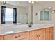 Bathroom featuring vanity with framed mirror and white countertop, alongside decorative lights and hardware at 11844 N 146Th Ave, Surprise, AZ 85379
