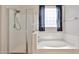 Modern bathroom with a glass enclosed shower, soaking tub, and natural light at 11844 N 146Th Ave, Surprise, AZ 85379