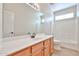 Bathroom featuring a vanity with wood cabinets, white countertops, and a tub-shower combo at 11844 N 146Th Ave, Surprise, AZ 85379