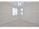 Bright bedroom with plush carpeting and ample light from the windows and ceiling fan at 11844 N 146Th Ave, Surprise, AZ 85379