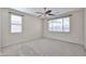 This spacious bedroom features carpet flooring, neutral walls, and dual windows for ample natural light at 11844 N 146Th Ave, Surprise, AZ 85379