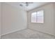 Bright bedroom featuring neutral carpeting, ceiling fan, and natural light from large window at 11844 N 146Th Ave, Surprise, AZ 85379