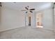 A neutral bedroom with carpet, fan, and en suite bathroom at 11844 N 146Th Ave, Surprise, AZ 85379