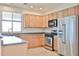 This kitchen features light wood cabinets, tiled floors, stainless steel appliances, and granite countertops at 11844 N 146Th Ave, Surprise, AZ 85379