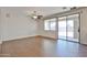 Bright living room with wood flooring, ceiling fan, and sliding door leading to the backyard at 11844 N 146Th Ave, Surprise, AZ 85379